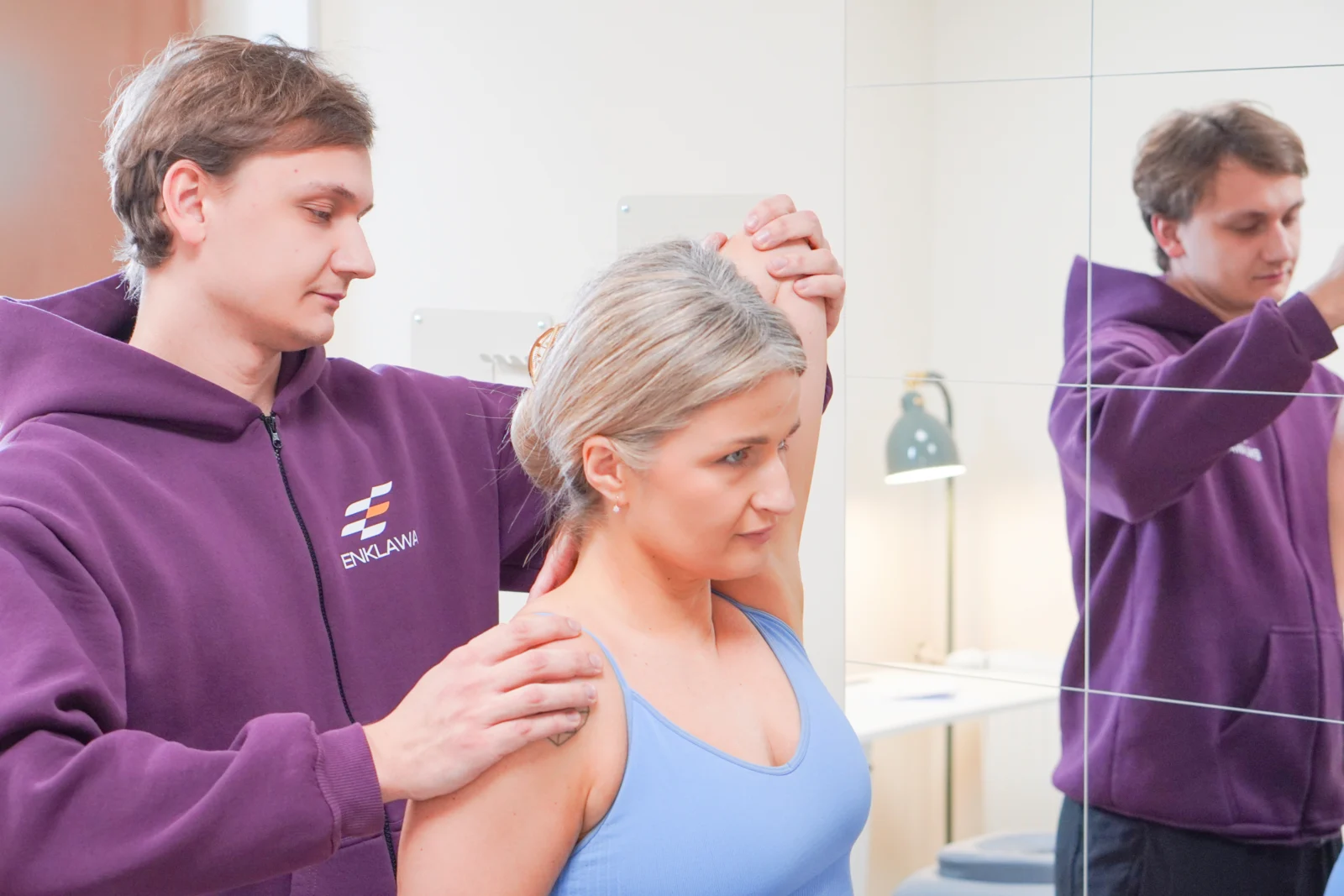 Fizjoterapeuta Enklawa Recovery rozciąga ramię pacjentki